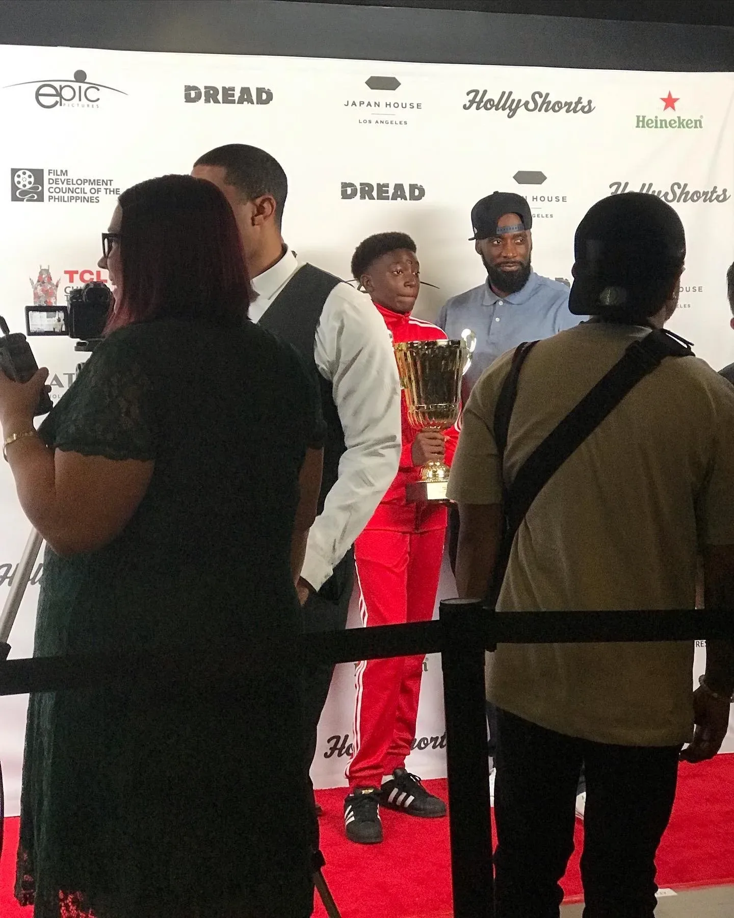 Guests on the red carpet in front of the sponsor wall.