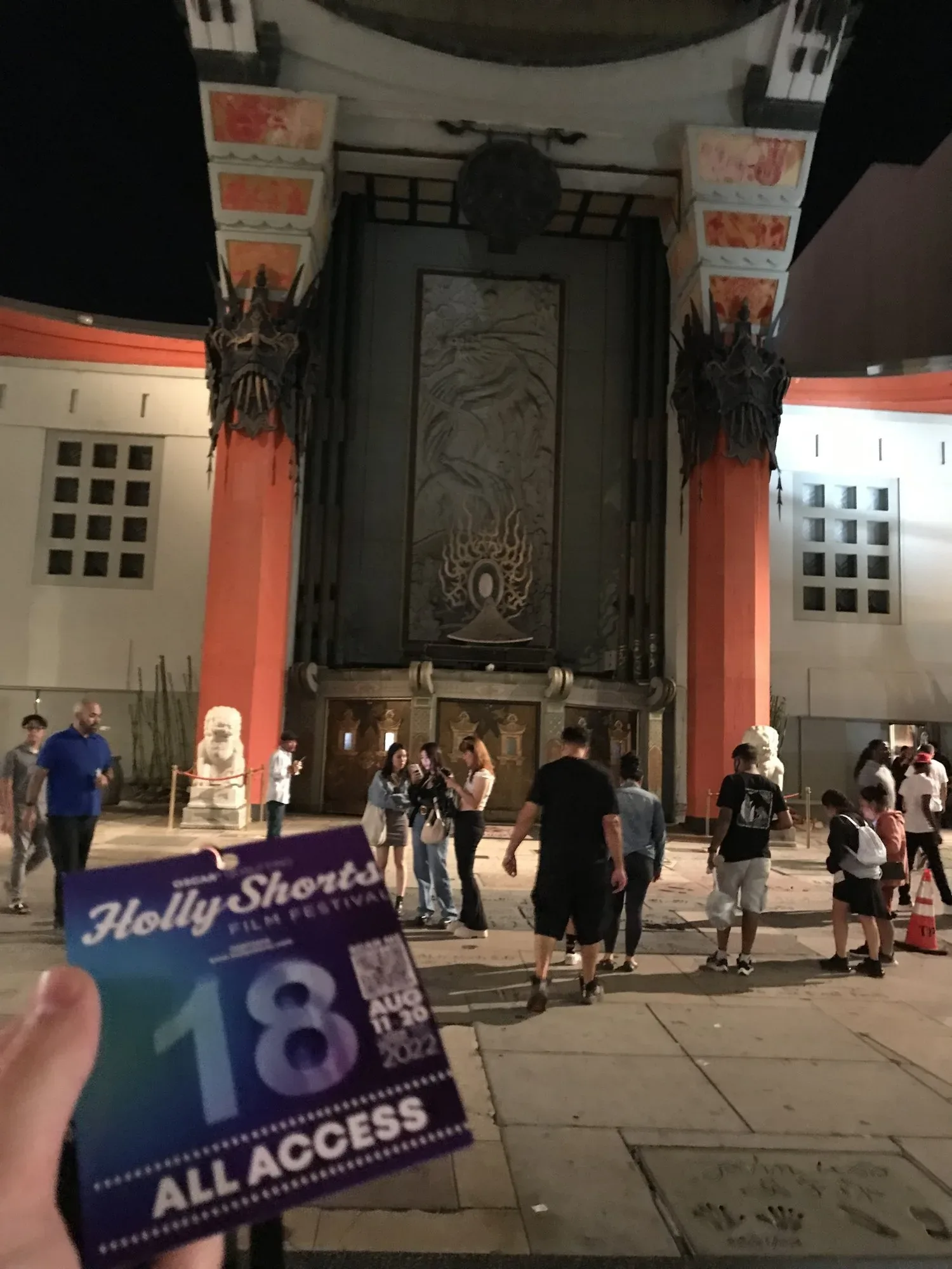 An All Access badge held up in the forecourt of the Chinese Theatre.