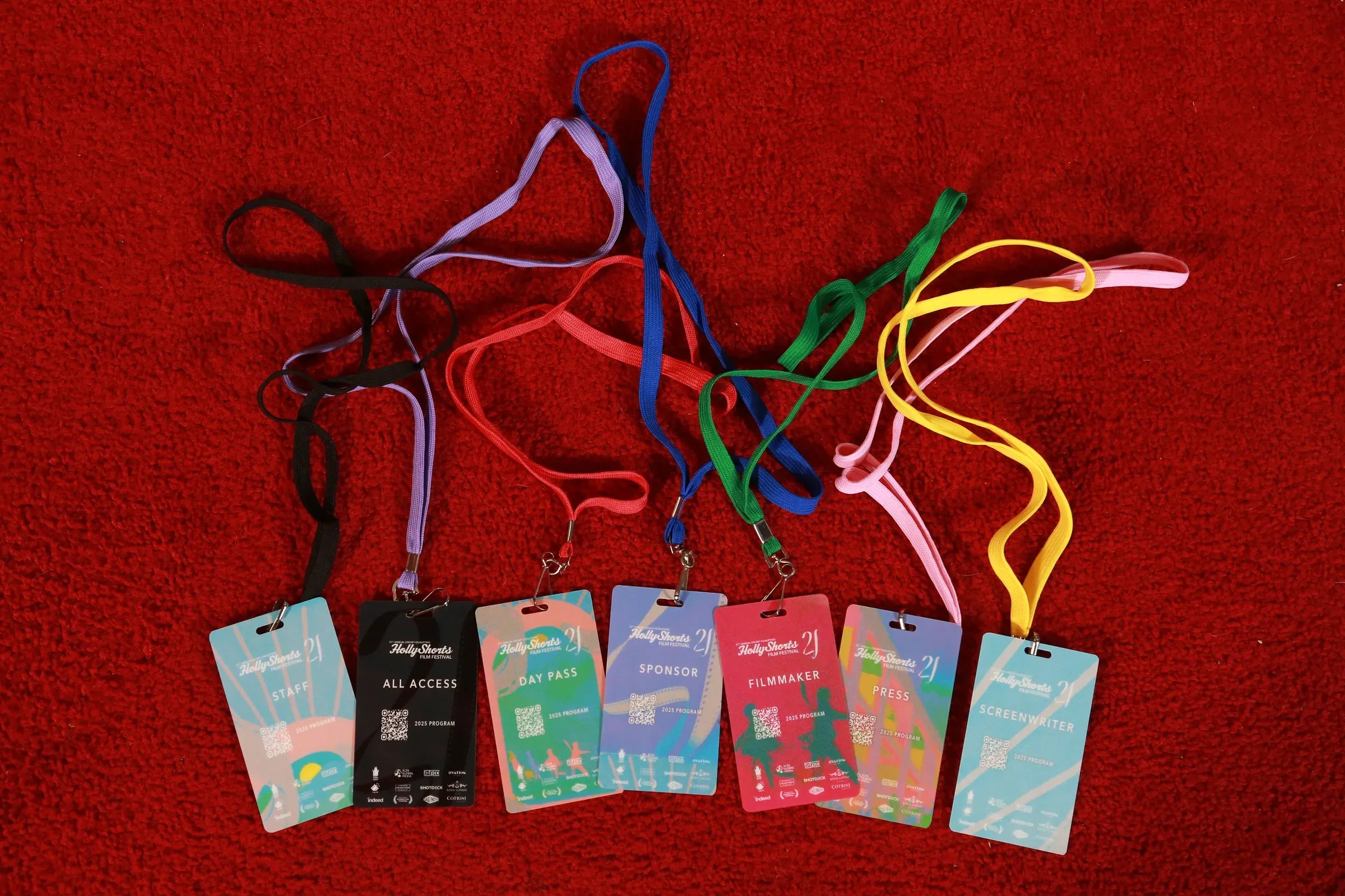 Badges and lanyards laid out on a red carpet