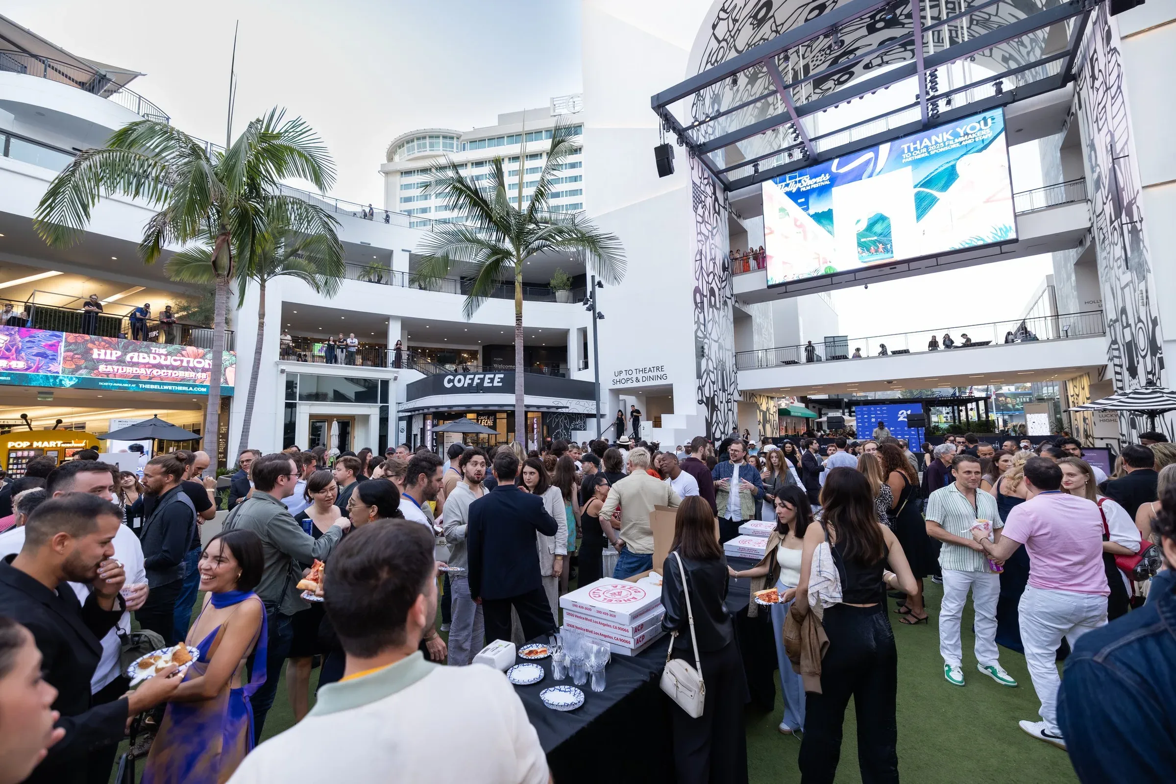 The festival crowd in the plaza, with the LED screen behind.
