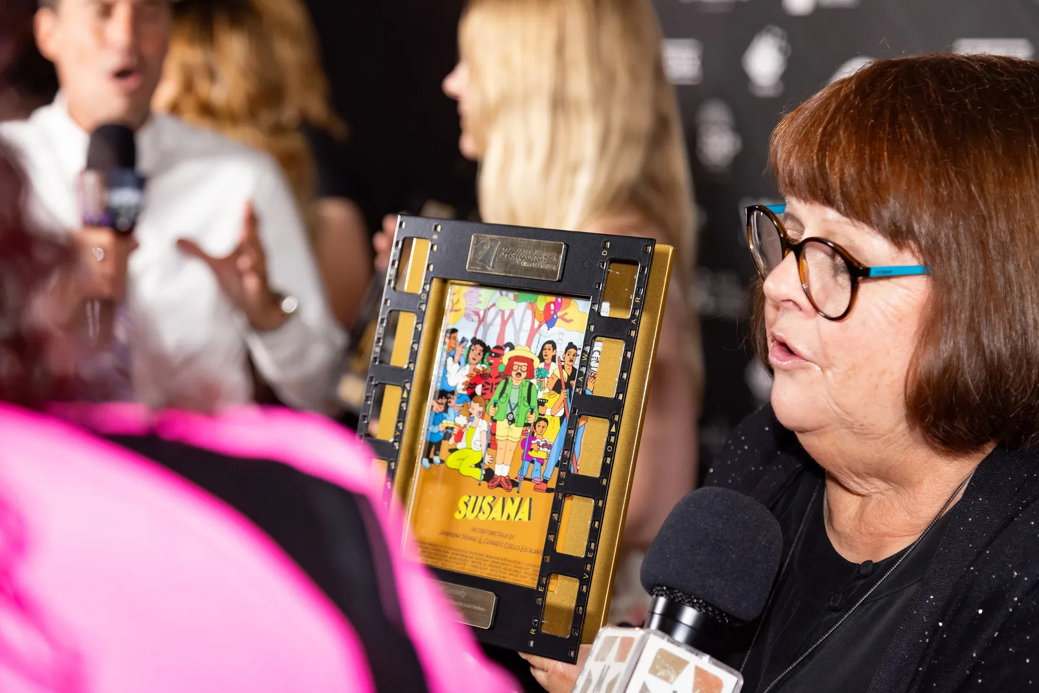 A winner interviewed while holding the framed award.