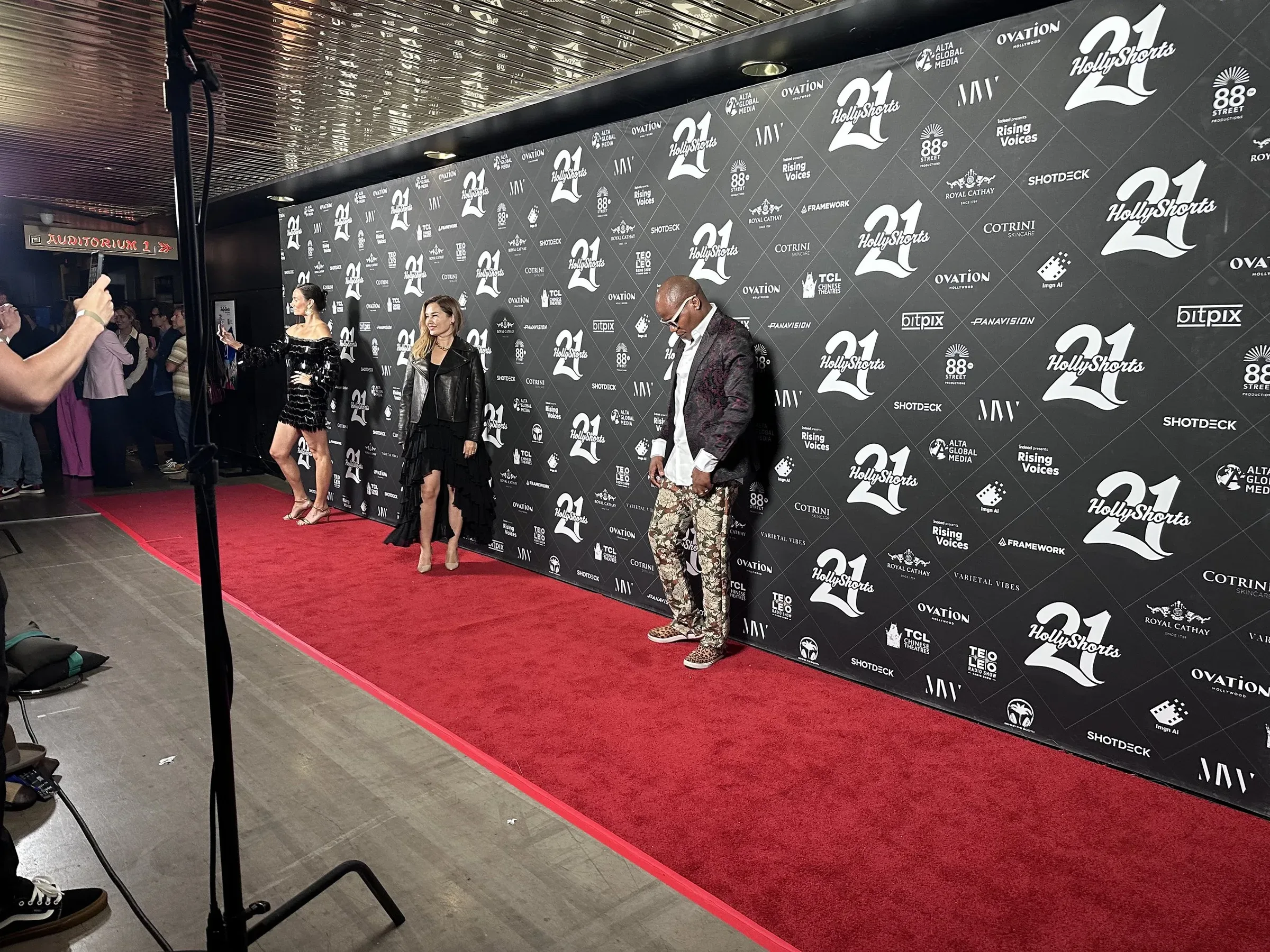 Guests on the red carpet at the black step-and-repeat