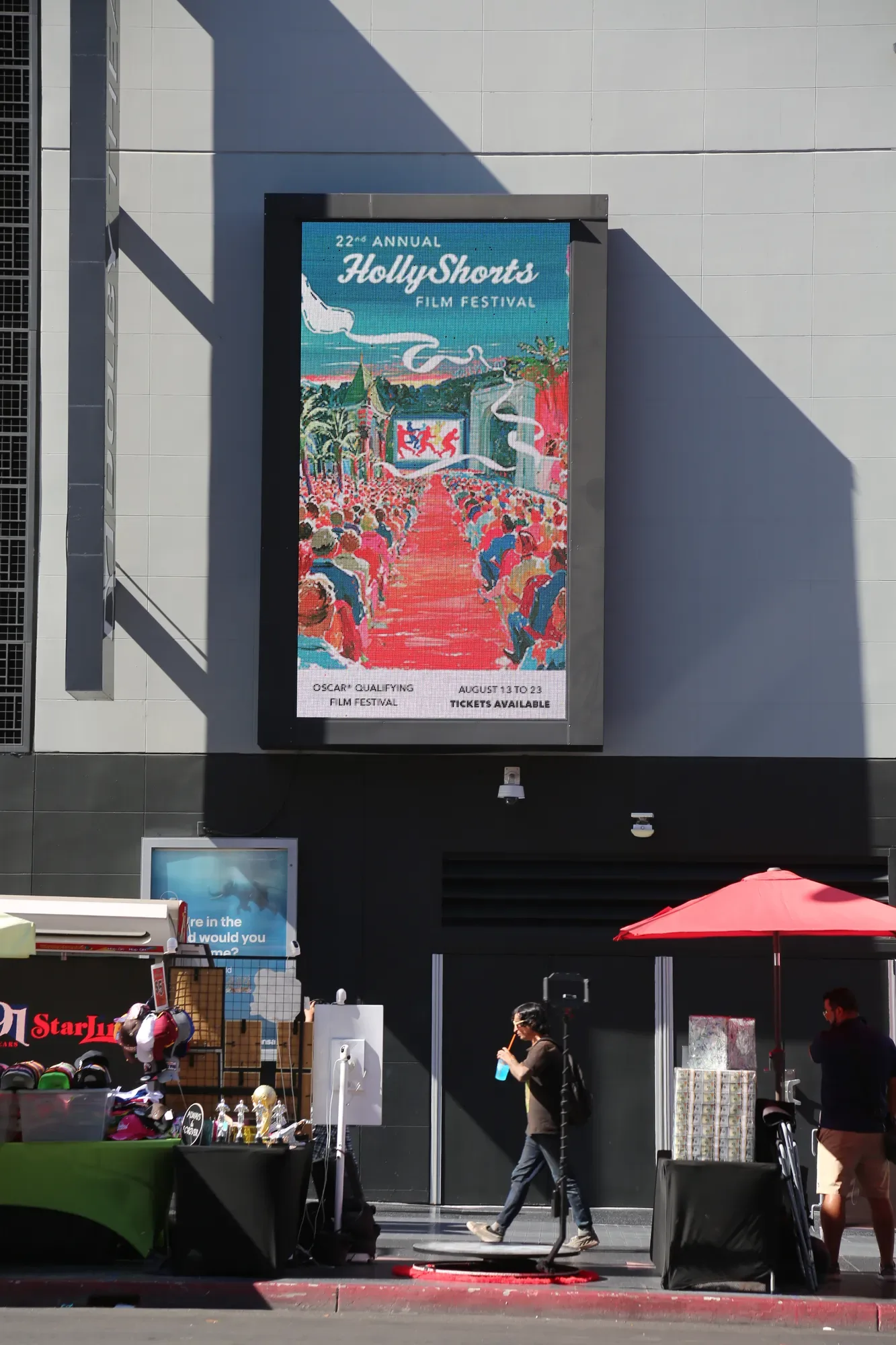 The poster on a building screen above the street.