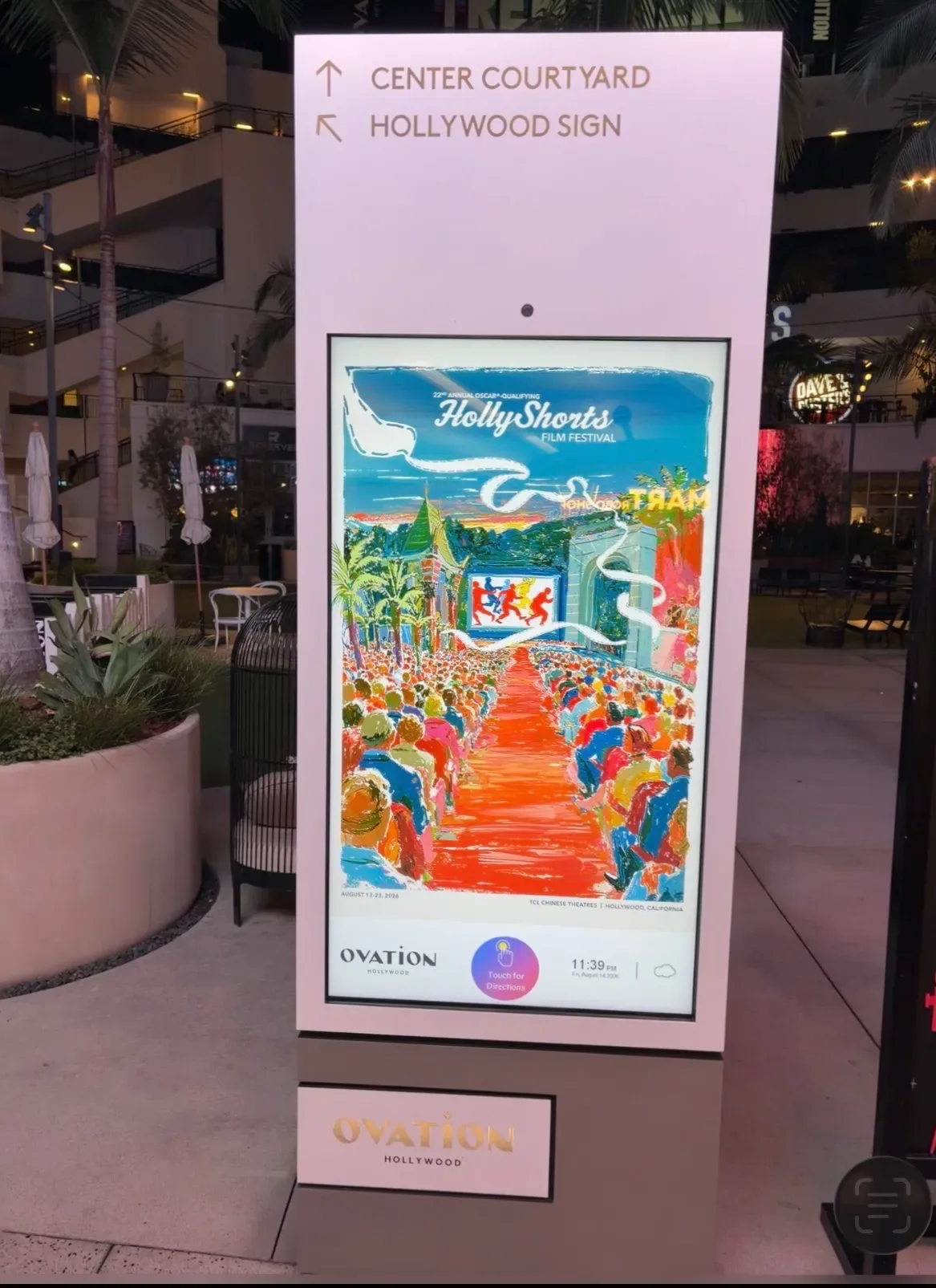 The poster on an Ovation Hollywood directory screen at night.