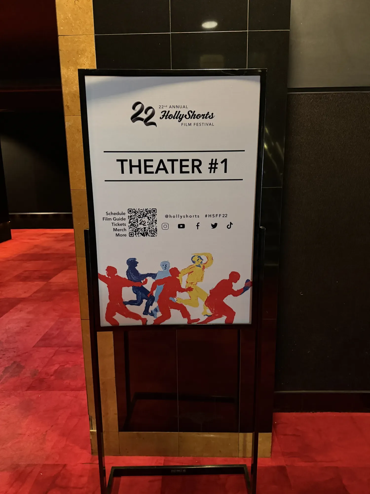 Theater wayfinding sign with the festival figures.