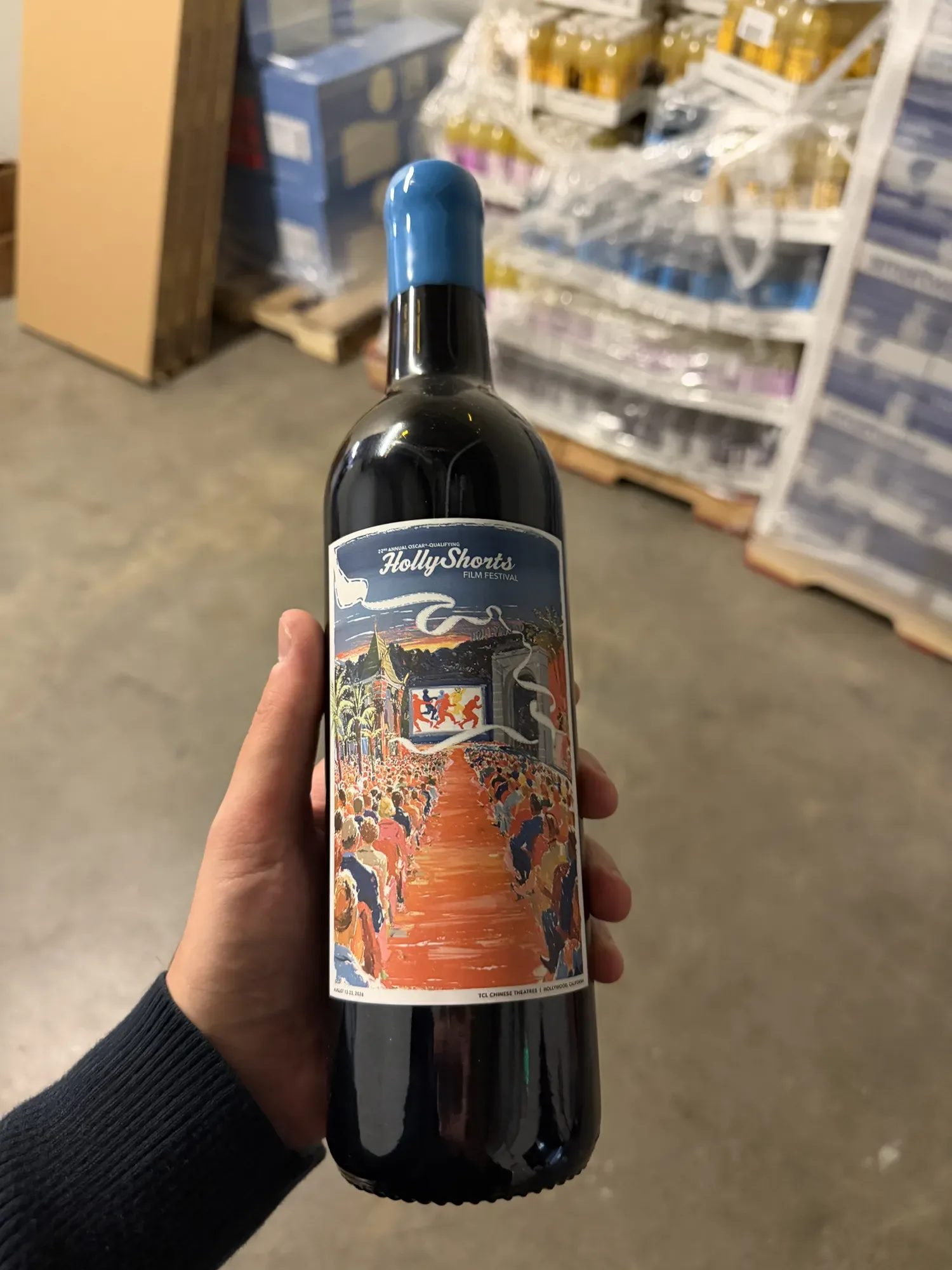 The Cabernet Sauvignon held in the hand, with the poster label.