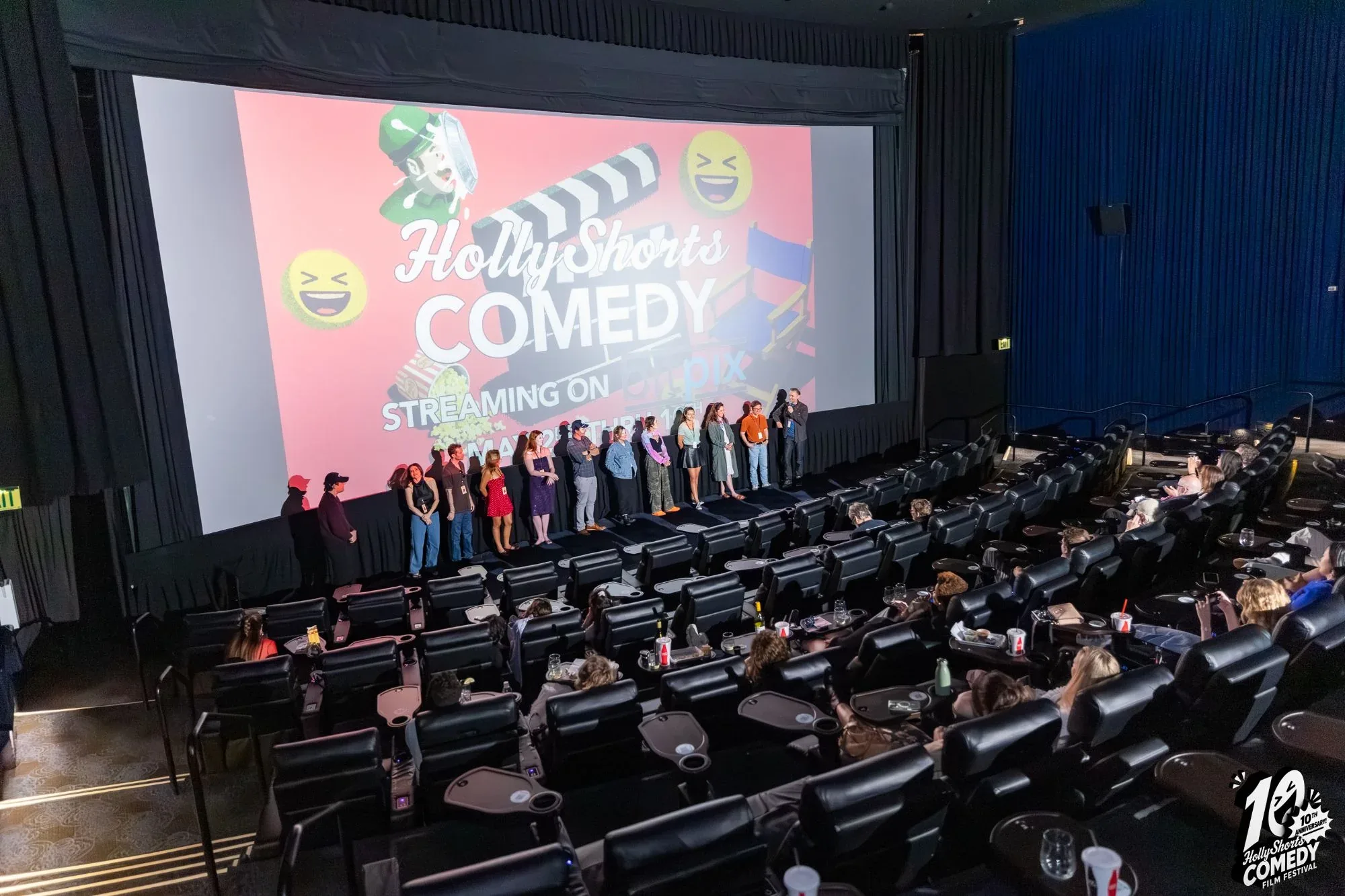 Filmmakers on stage for a Q&A, with the HollyShorts Comedy slide on the screen behind them.