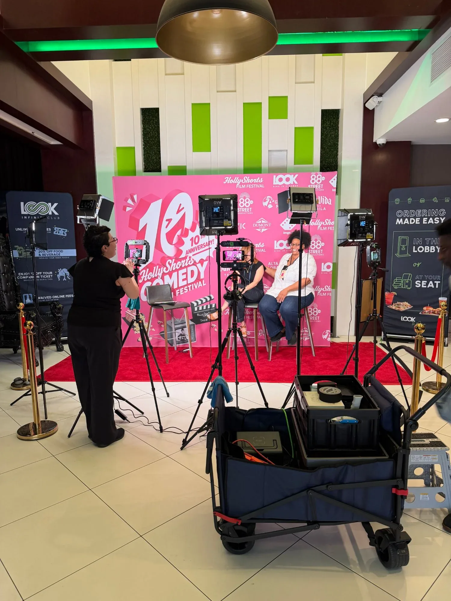 An interview being filmed at the step-and-repeat in the lobby