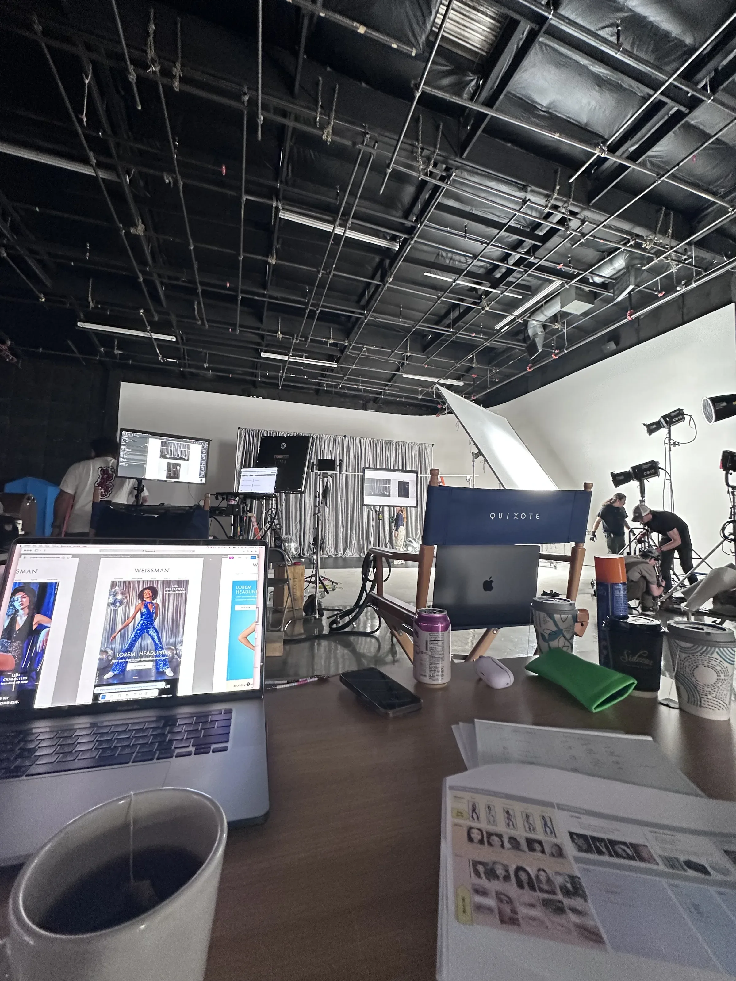 A laptop with website layouts beside the printed shot sheet.