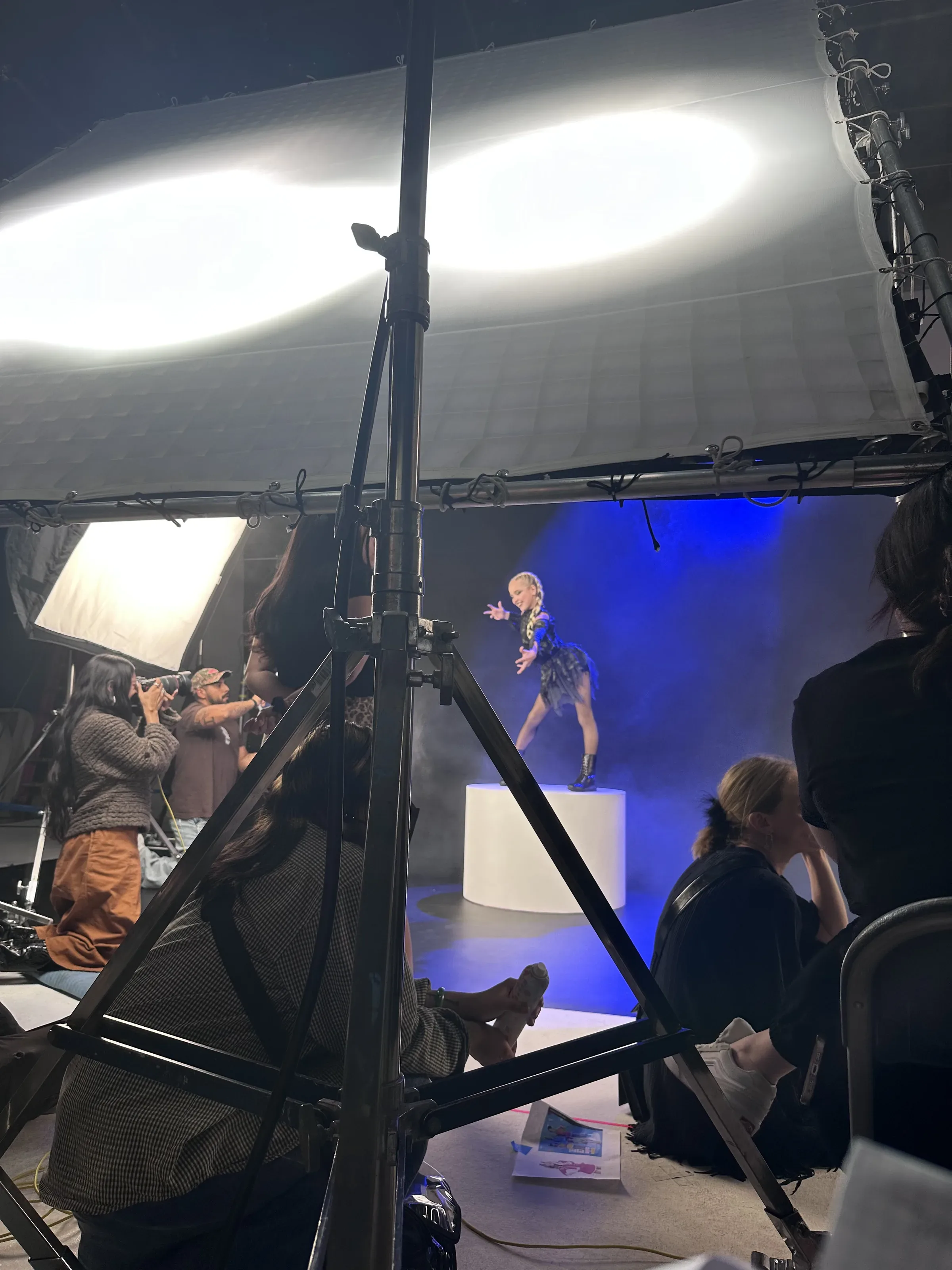 On set: the Roaring 20s set, a dancer on a white pedestal in blue haze.